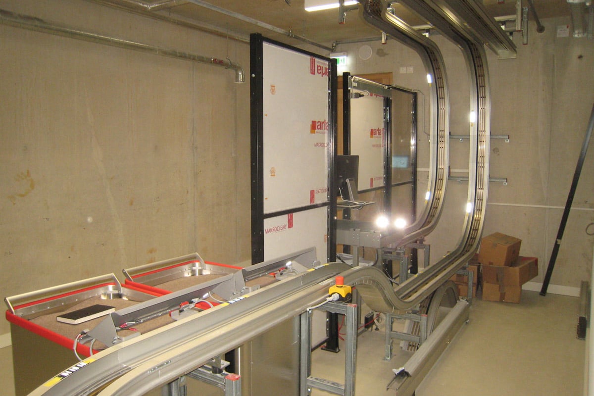 Die Förderanlage besteht aus einem Schienensystem, das sowohl horizontal als auch vertikal installiert wurde. Die Schienenführung besteht aus geraden und gebogenen Schienensegmenten und wird in Mindestradien in den dafür vorgesehenen Gebäudeabschnitten installieren. 
